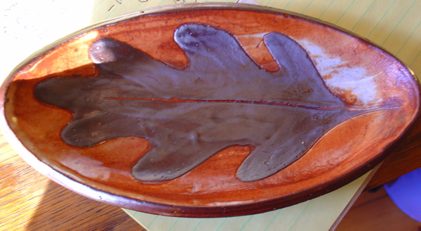 stoneware drop plate with white layer of porcelain slip under black slip oak leaf -shino glaze