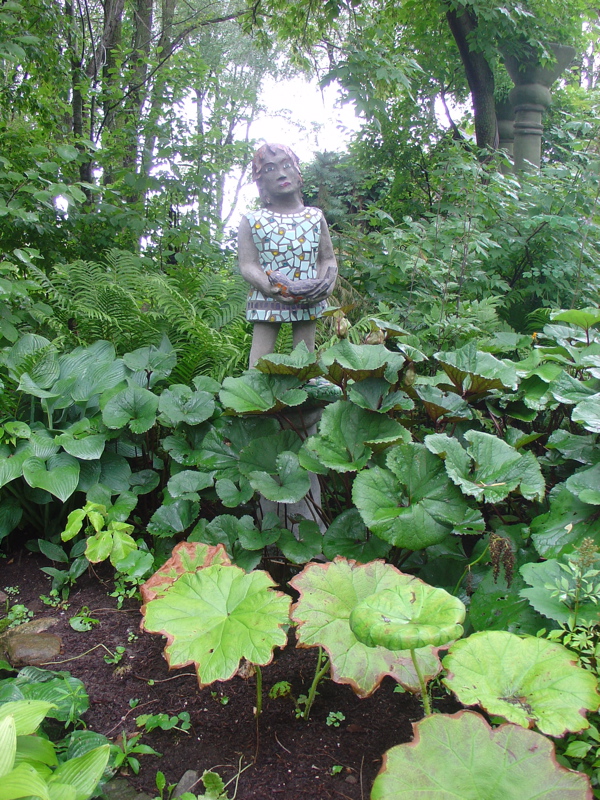 little girl statue among plantings